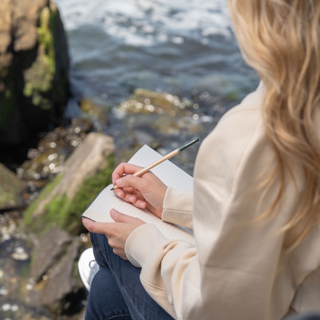 Woman journaling by the ocean