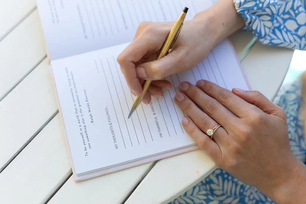 Woman writing in gratitude journal 