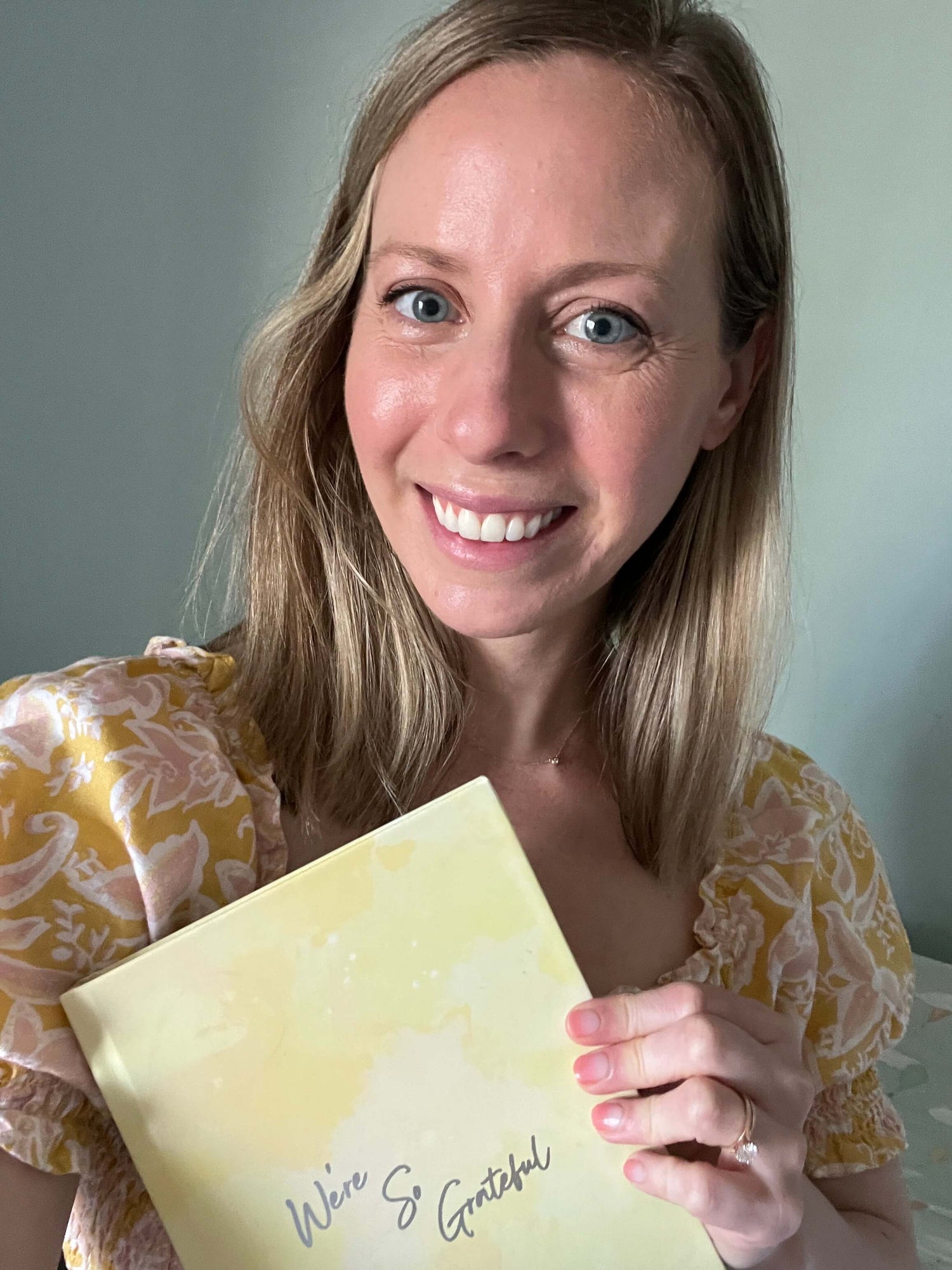 woman in yellow dress holding yellow gratitude journal