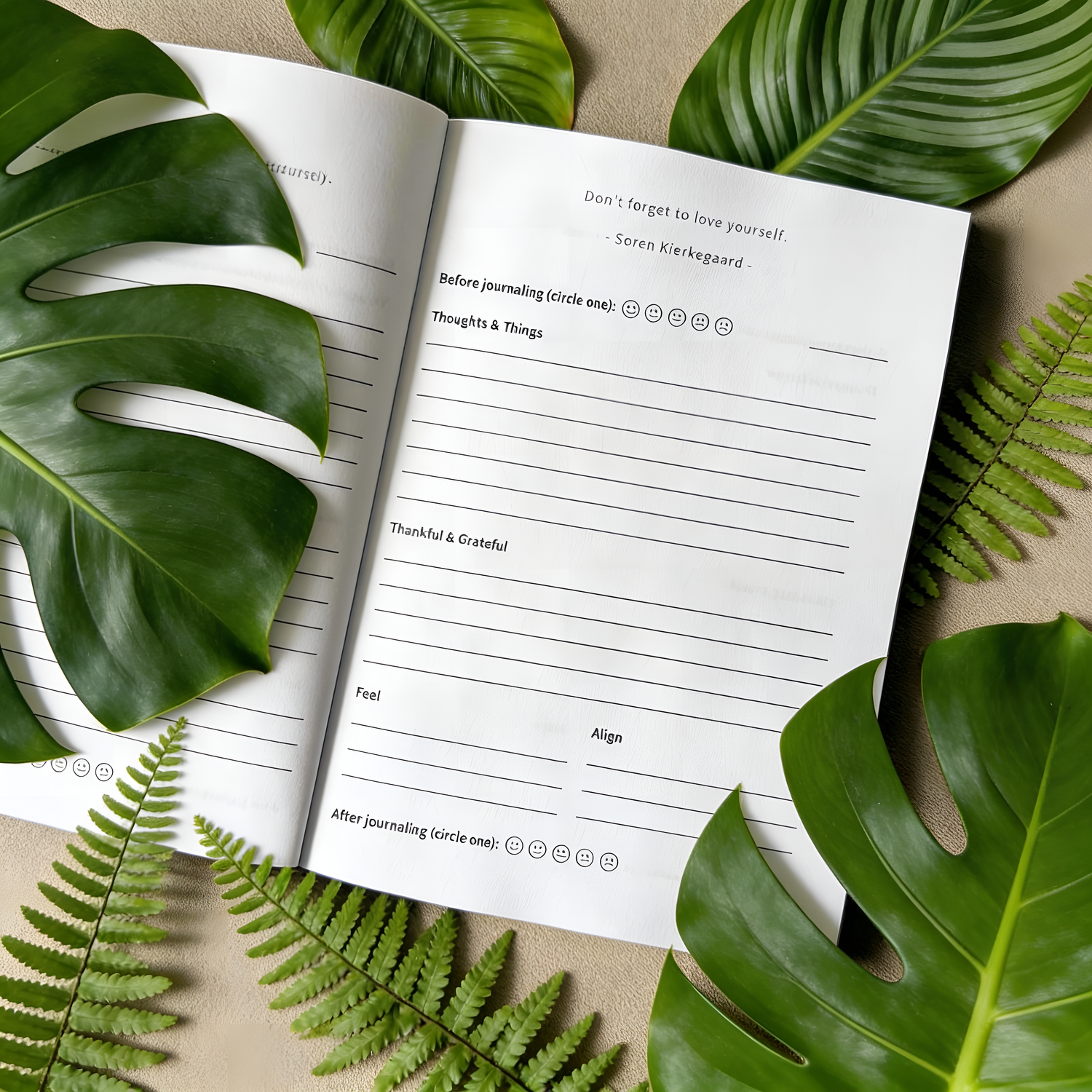 Open journal for beginners with lined pages surrounded by green leaves on a beige background