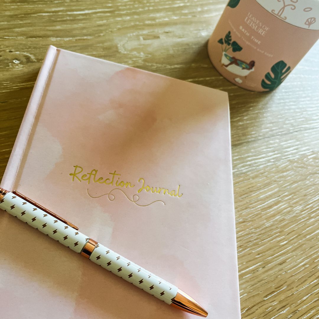 pink journal with gold pen and winter tea